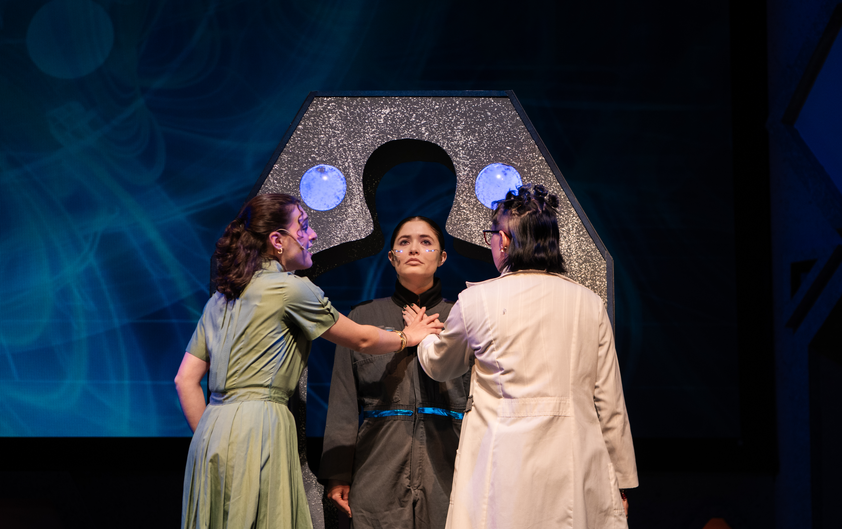 Theatre production with three women on stage